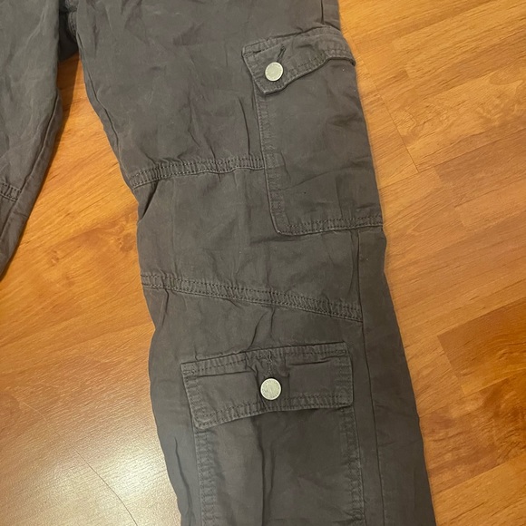 Grey cargos with pockets all over the front of it and visible grey seams. - Picture 2 of 5